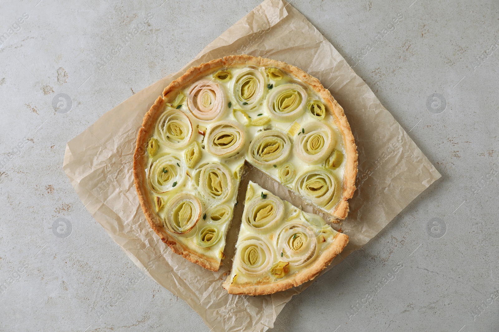 Tasty leek pie on grey textured table, top view Photo of Tasty leek pie on grey textured table, top view