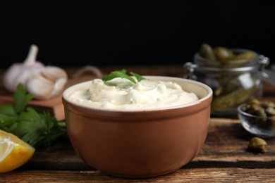 Photo of Tasty tartar sauce and ingredients on table, closeup