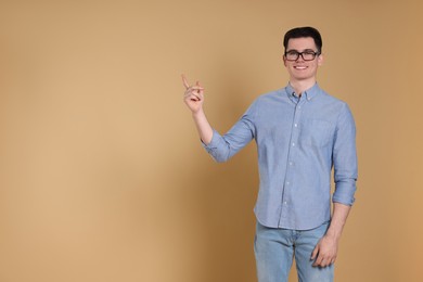 Photo of Portrait of handsome young man gesturing on beige background, space for text