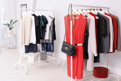 Photo of Wardrobe racks with different stylish clothes in light room