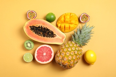 Fresh ripe papaya and other fruits on yellow background. flat lay