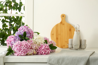Beautiful hydrangea flowers bouquet on light countertop