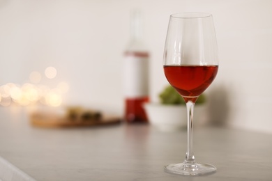 Photo of Glass of delicious wine on table, space for text. Bokeh effect