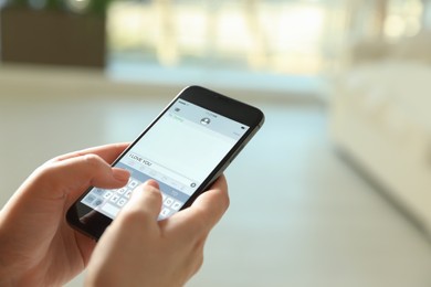 Photo of Woman writing message I Love You on smartphone against blurred background, closeup. Space for text
