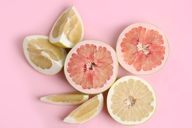 Photo of Fresh cut pomelo fruits on pink background, flat lay