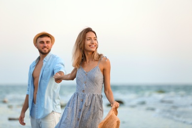 Photo of Young couple spending time together on beach