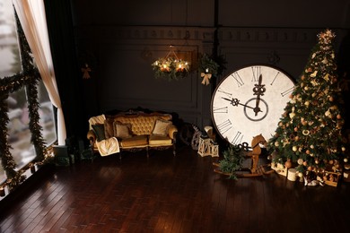 Photo of Stylish room interior with Christmas tree, big vintage clock and festive decor