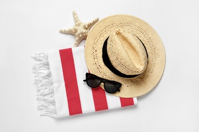 Photo of Beach towel, straw hat and sunglasses on light background, flat lay