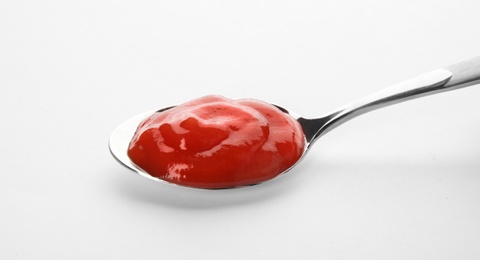 Photo of Tasty homemade tomato sauce in spoon on white background