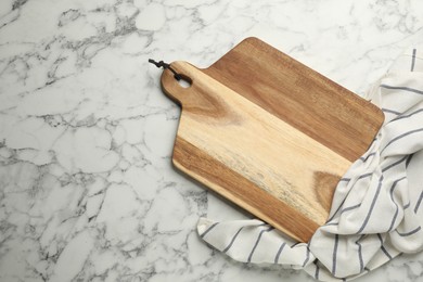 Photo of Wooden cutting board and kitchen towel on white marble table, flat lay with space for text. Cooking utensil