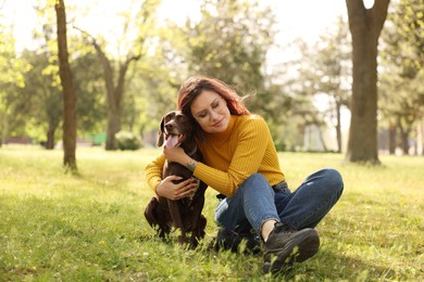 Photo of Woman with her cute German Shorthaired Pointer dog in park on spring day