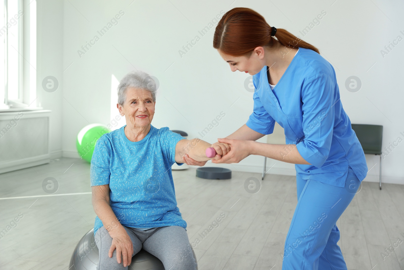 Photo of Professional physiotherapist working with elderly patient in rehabilitation center