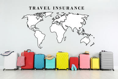 Image of Colorful suitcases and phrase TRAVEL INSURANCE on light background