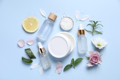 Photo of Flat lay composition with bottles of cosmetic serum on light blue background