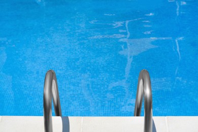 Photo of Swimming pool with metal ladder on sunny day, above view