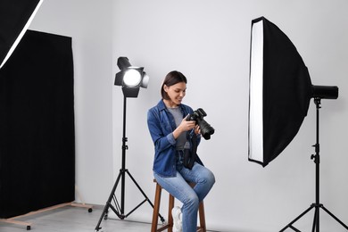 Photo of Professional photographer with camera in modern photo studio