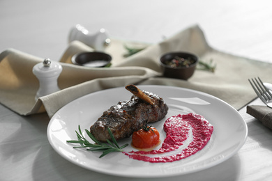 Photo of Delicious roasted rib served on white wooden table