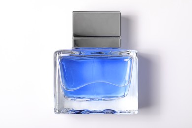 Photo of Blue men's perfume in bottle on white background, top view