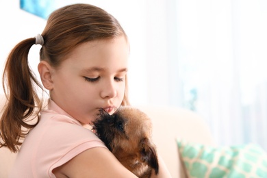 Photo of Portrait of cute girl with funny Brussels Griffon dog at home, space for text. Loyal friends