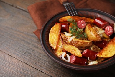 Photo of Delicious baked potato with thin dry smoked sausages, onion and dill in bowl on wooden table, closeup. Space for text