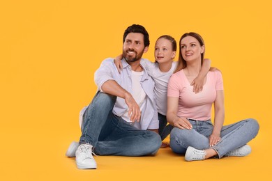 Photo of Happy family on orange background, space for text