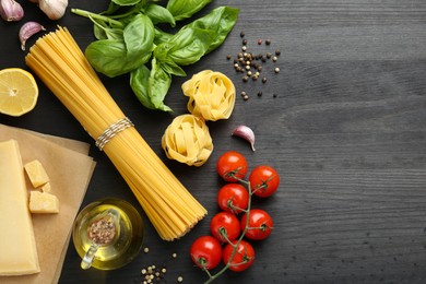 Photo of Different types of pasta, products and peppercorns on dark wooden table, flat lay. Space for text