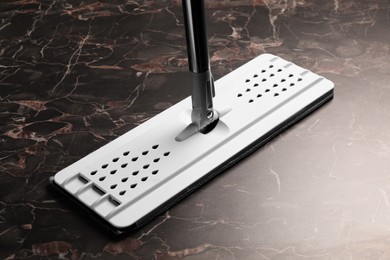 Photo of Cleaning black marble floor with mop, closeup
