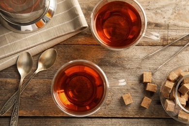 Photo of Flat lay composition with glass cups of black tea on wooden table