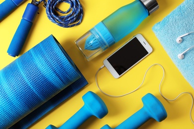 Photo of Flat lay composition with fitness gym equipment on color background