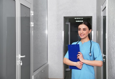 Photo of Portrait of nurse with clipboard in hospital hallway. Medical assisting