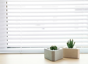 Photo of Window with blinds and potted plants on sill, space for text