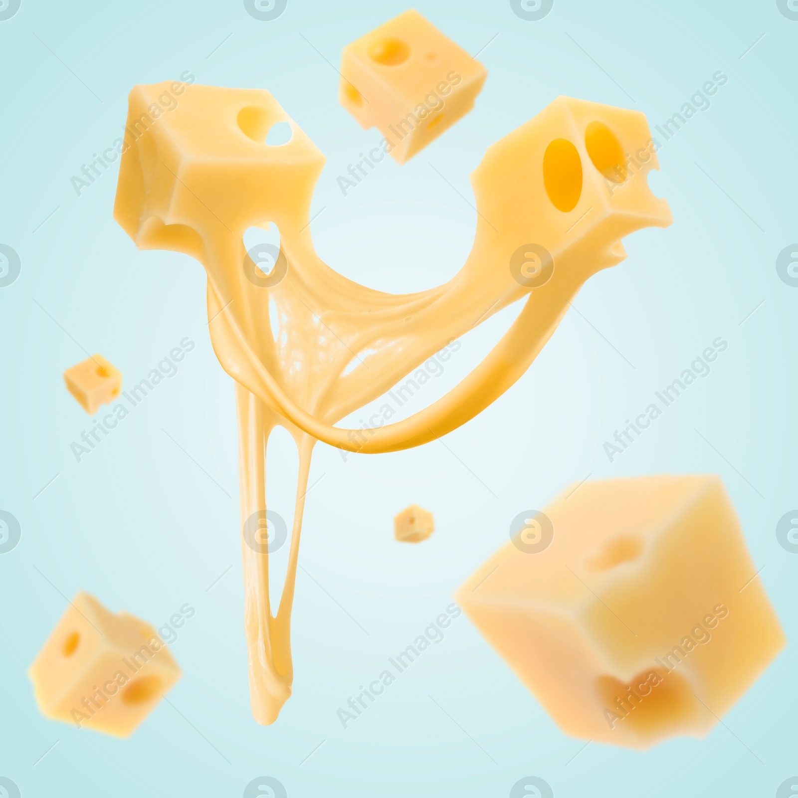 Image of Piecescheese falling on light blue background
