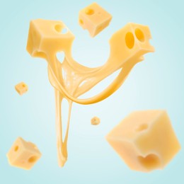 Image of Pieces of cheese falling on light blue background