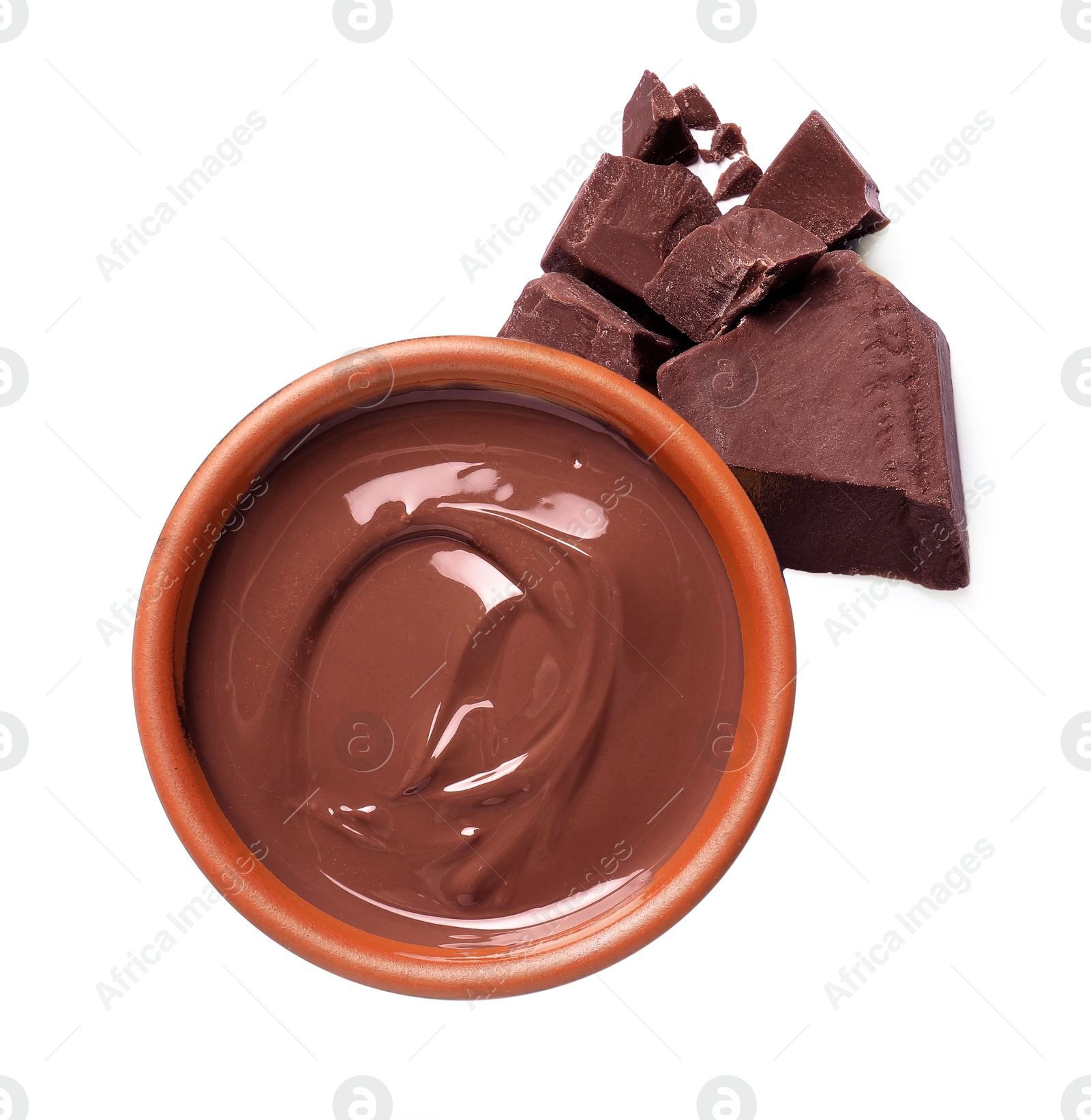 Photo of Tasty milk chocolate paste in bowl and pieces isolated on white, top view