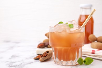 Freshly made tamarind juice with mint on white marble table, closeup. Space for text