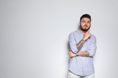 Portrait of handsome young man against light background. Space for text