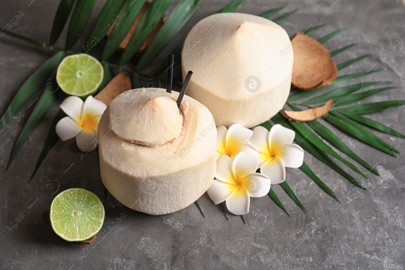 Photo of Composition with fresh coconut drink in nut on grey background