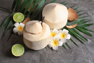 Photo of Composition with fresh coconut drink in nut on grey background