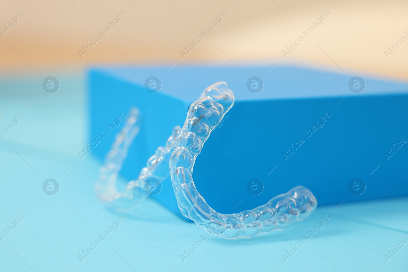 Photo of Transparent dental aligners on color background, closeup