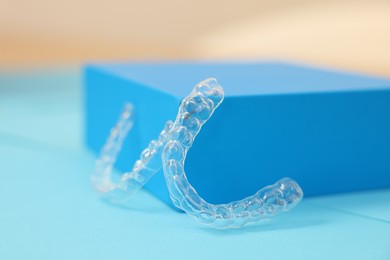 Photo of Transparent dental aligners on color background, closeup