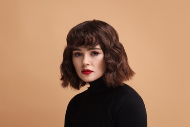 Portrait of beautiful young woman with wavy hairstyle on beige background