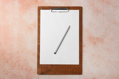 New clipboard with sheet of blank paper and pencil on color textured table, top view