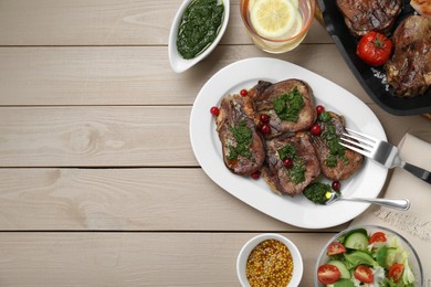 Photo of Tasty beef tongue pieces, salsa verde, berries, mustard and salad on beige wooden table, flat lay. Space for text