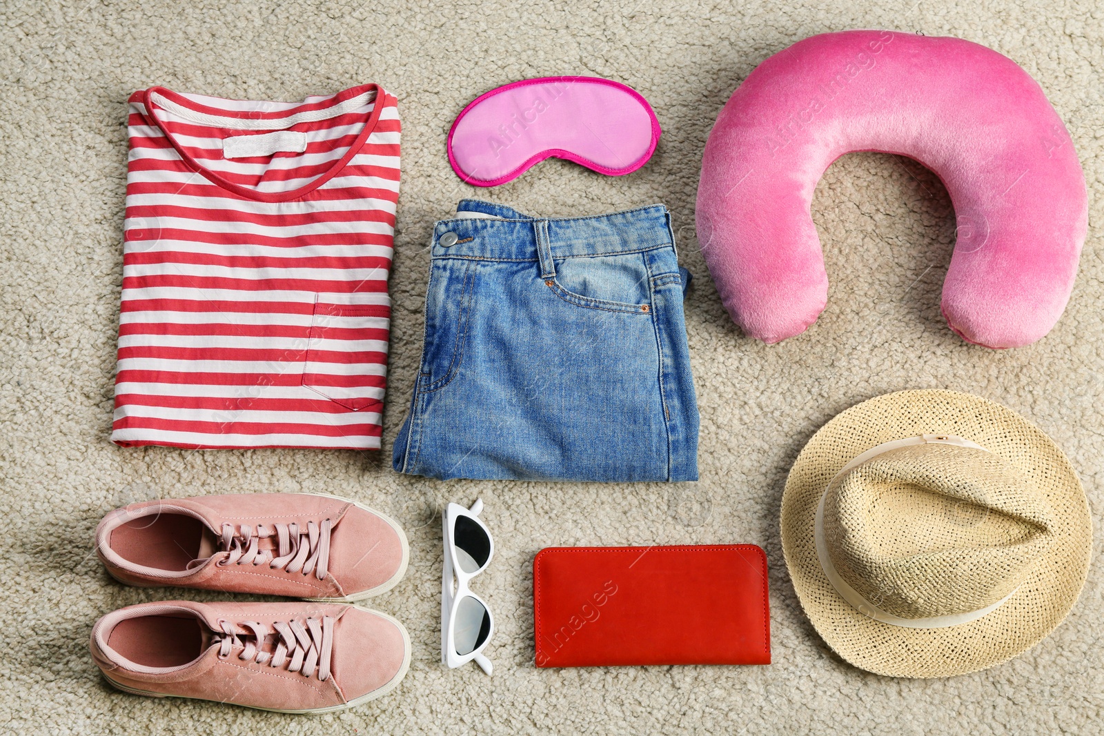 Photo of Flat lay composition with travel pillow and tourist stuff on soft carpet