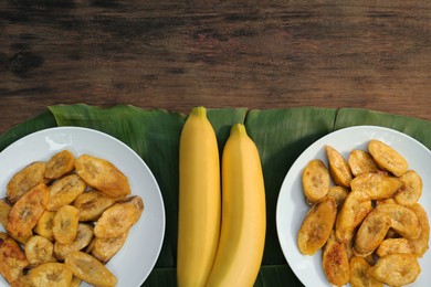 Photo of Tasty deep fried banana slices and fresh fruits on wooden table, flat lay. Space for text
