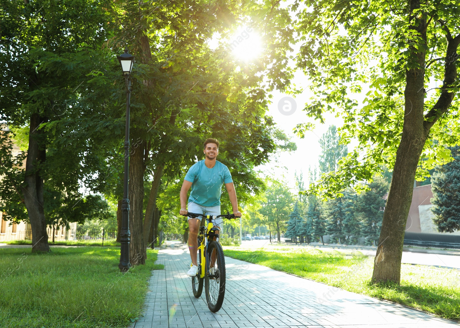 Photo of Handsome young man riding bicycle on city street