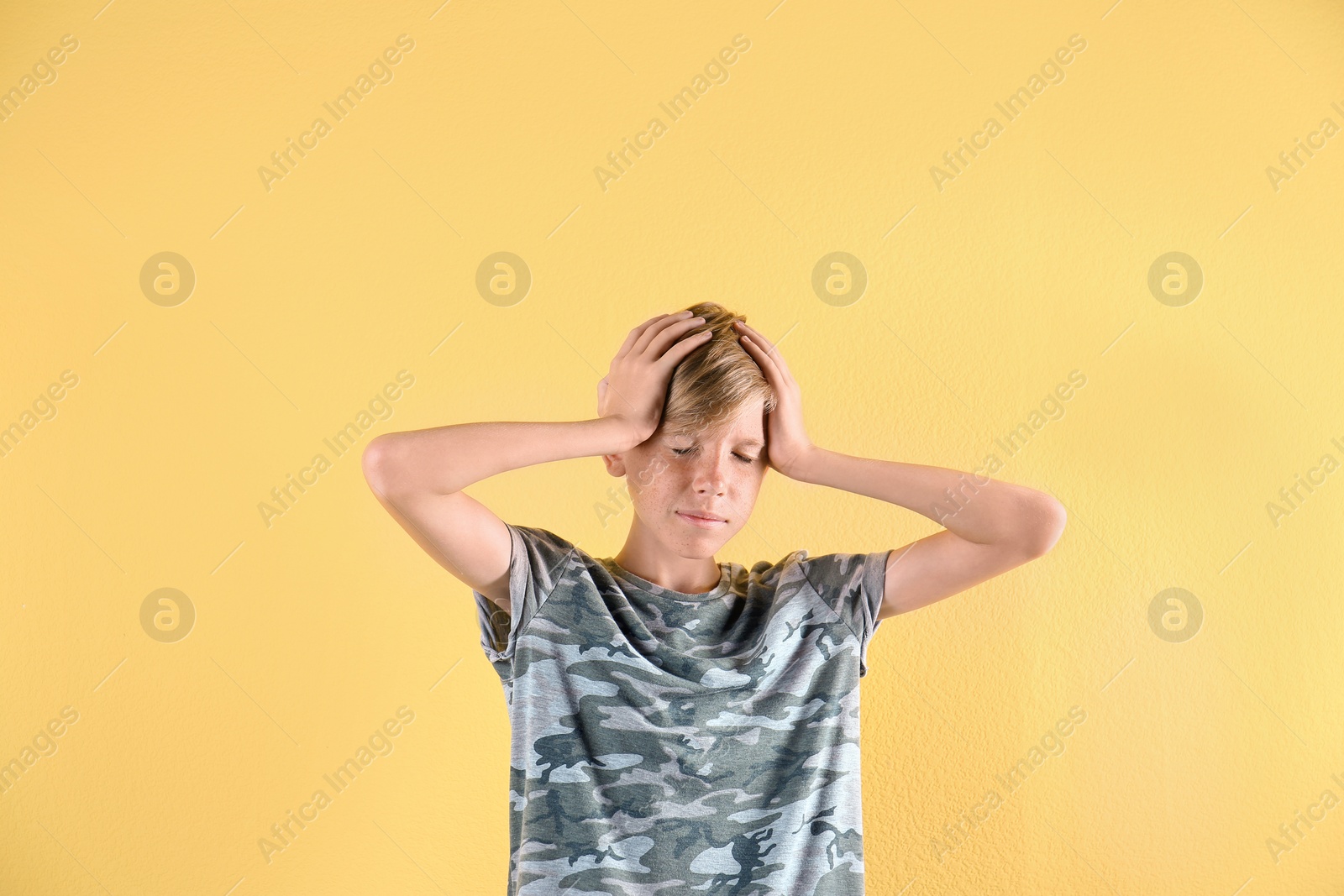 Photo of Portrait of young boy standing against color background