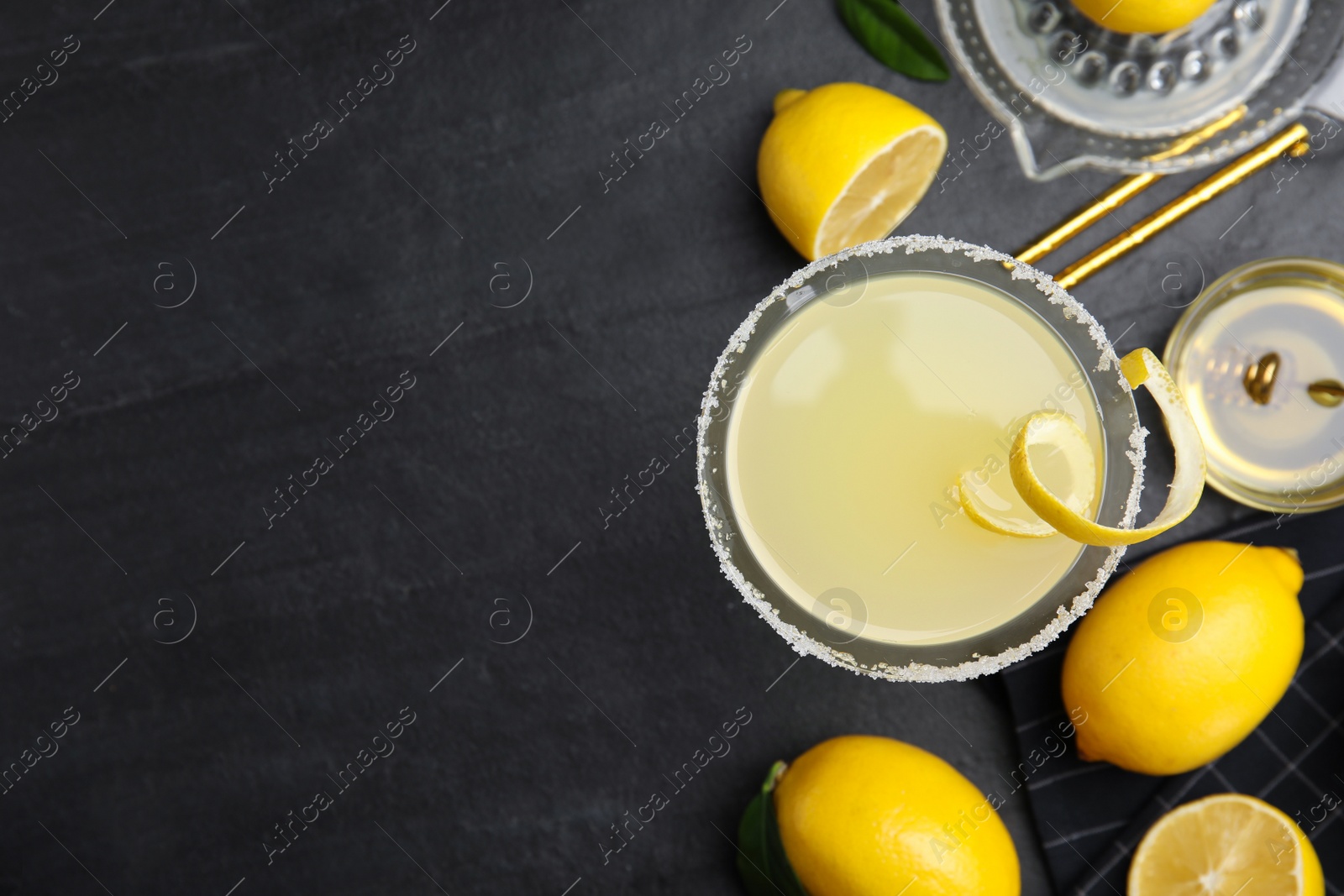 Photo of Delicious bee's knees cocktail and ingredients on black table, flat lay. Space for text