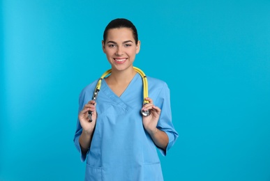 Photo of Portrait of young medical assistant with stethoscope on color background