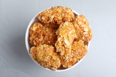 Photo of Bucket with yummy nuggets on light background, top view